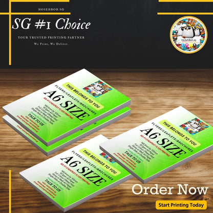 Custom A6 size flyers on a wooden table, showcasing vibrant designs for impactful marketing in Singapore.